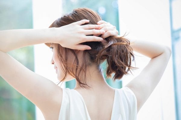 脱毛を終え晴れやかな気持ちで髪を束ねる女性