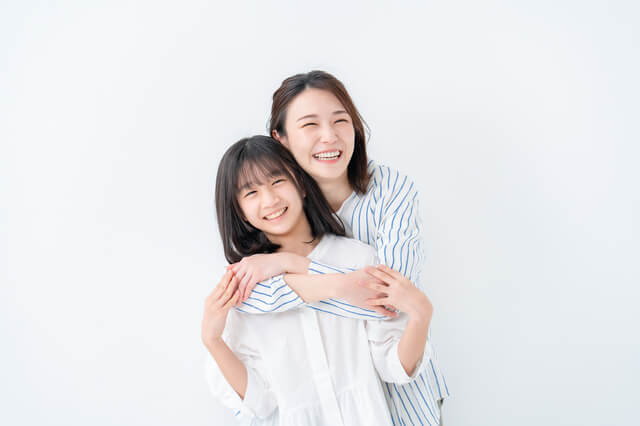うしろから娘を抱きしめる母