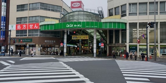 商店街の緑の看板が奥に見える大きな交差点
