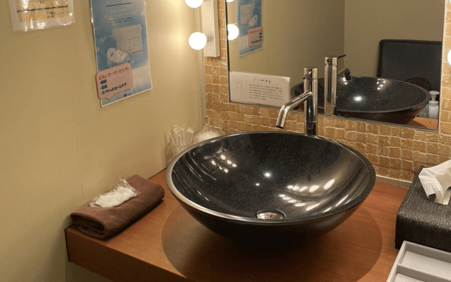 鏡とライトと洗面台があるジュノビューティークリニック芦屋院のパウダースペース