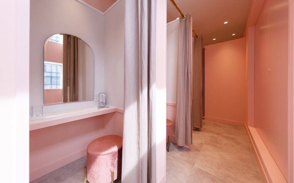 ピンクを基調とし、鏡と机と椅子があるジュノビューティークリニック錦糸町院のパウダールーム