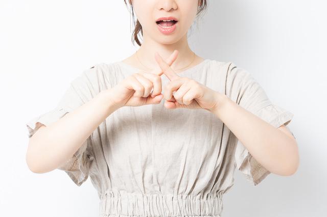 バツマークをしている女性
